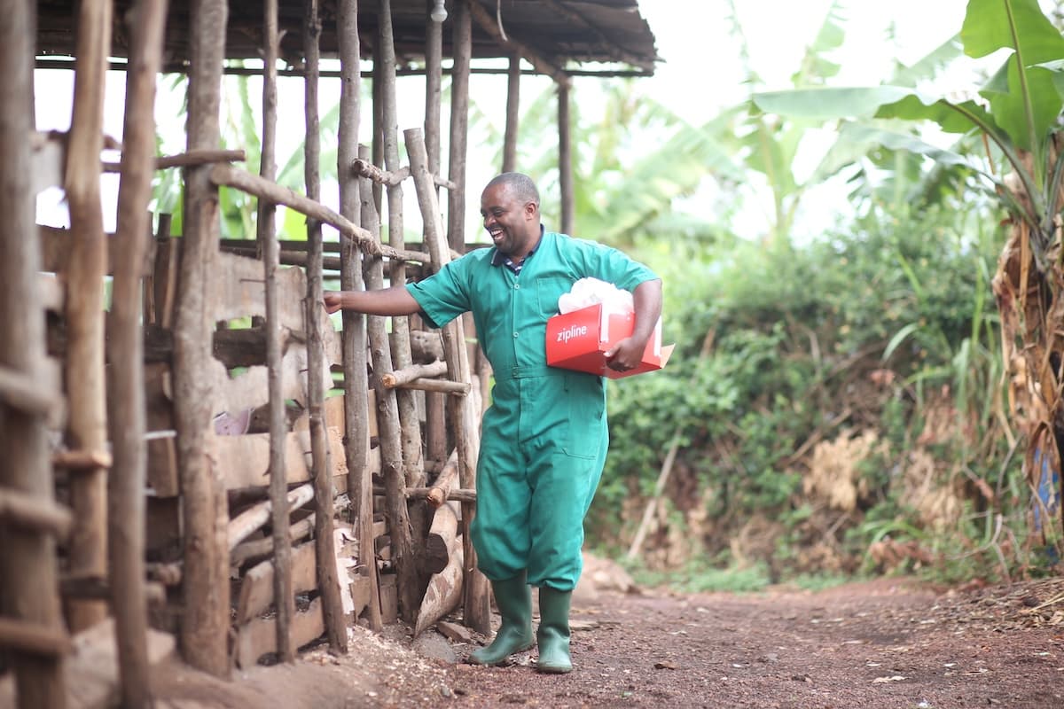 Farmer holding his Pig semen delivery from Zipline