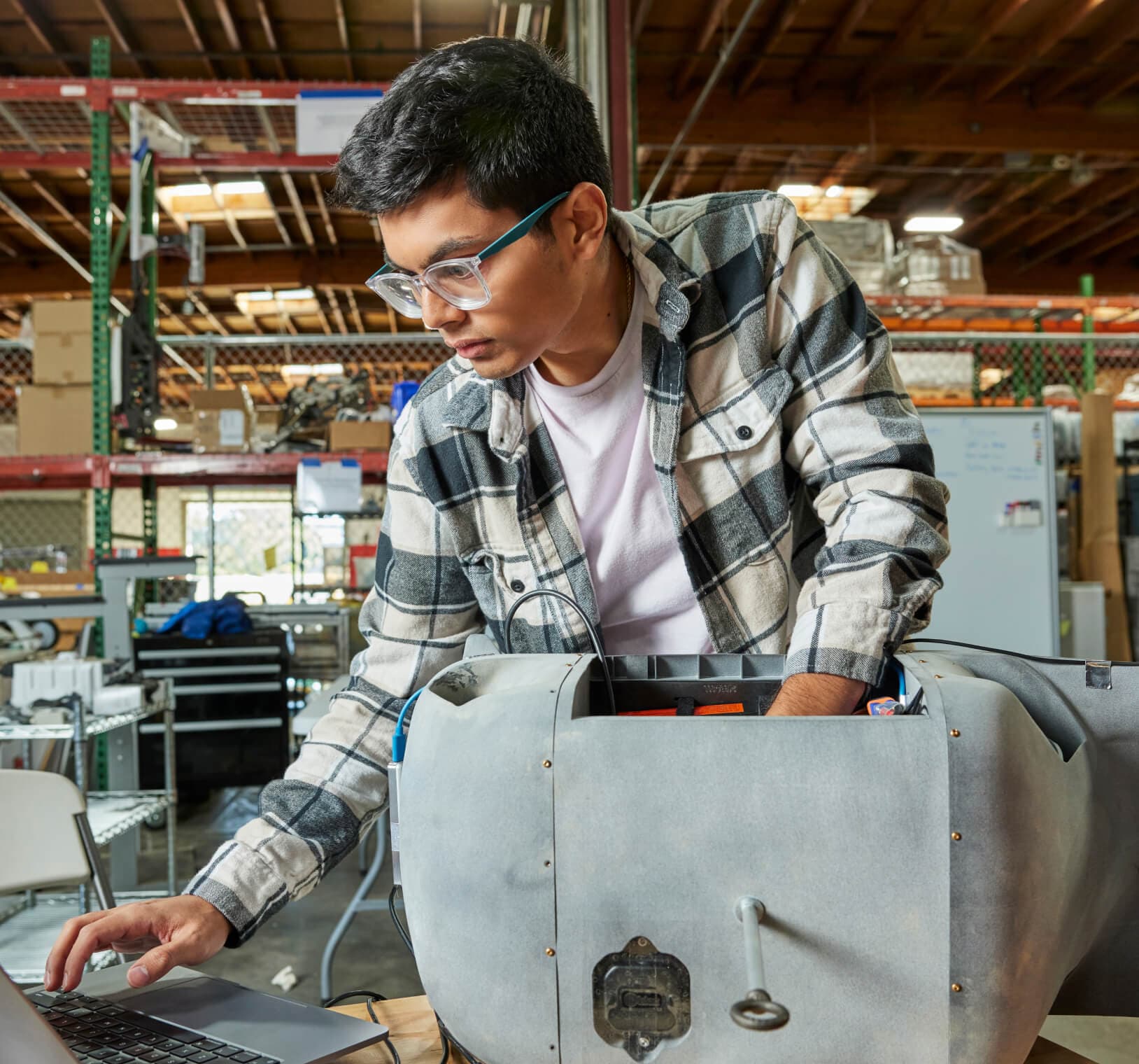Person inspecting a drone component in a workshop.