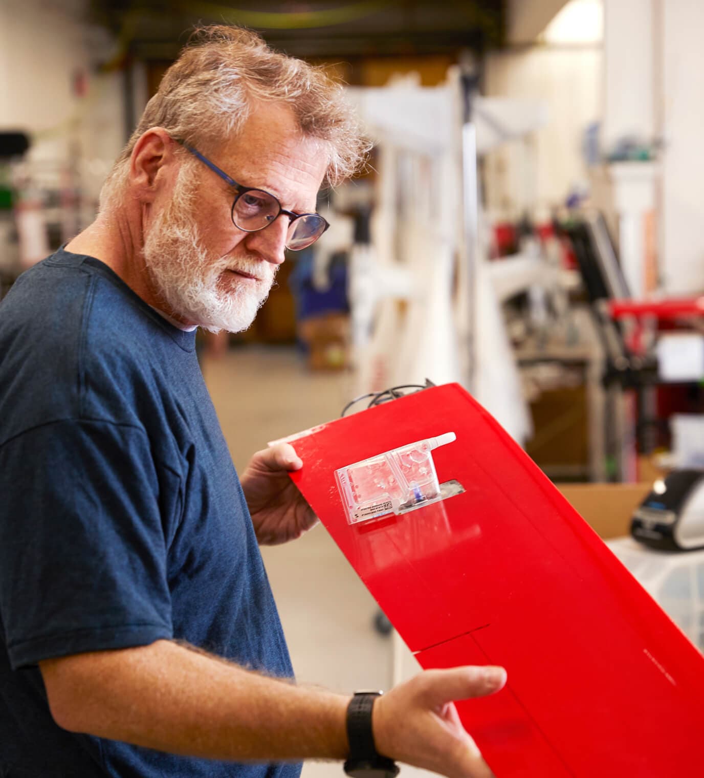 Person inspecting a drone wing component in a workshop.