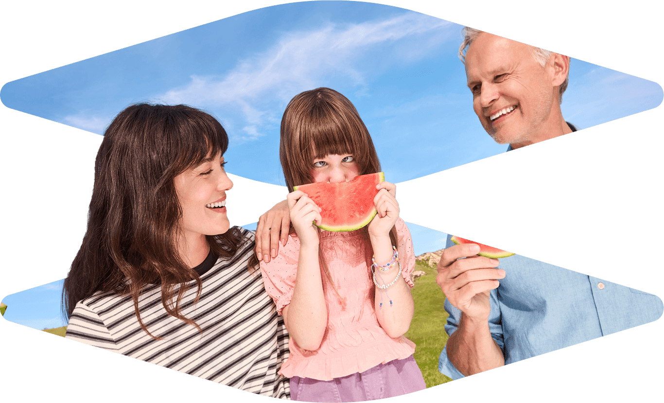 Family enjoying watermelon slices outdoors.