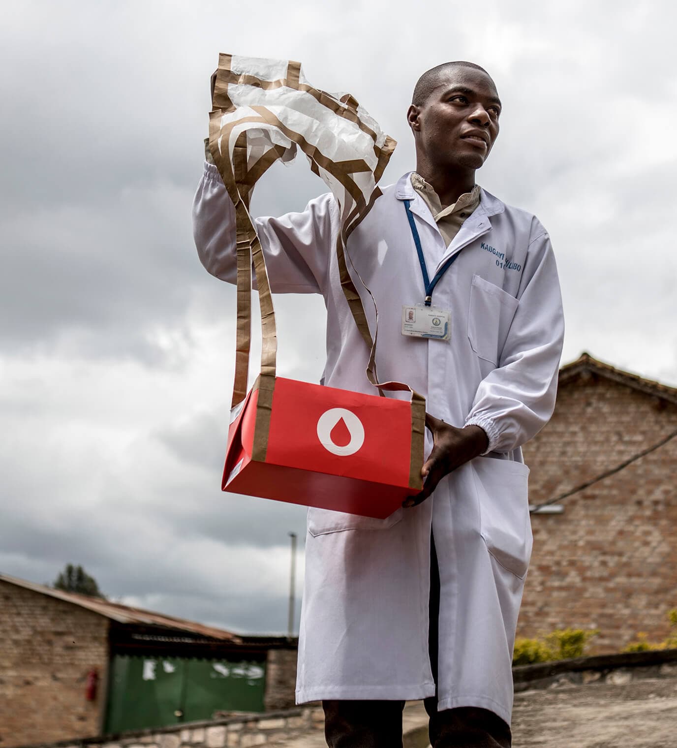 Healthcare worker holding a parachute delivery package outdoors.