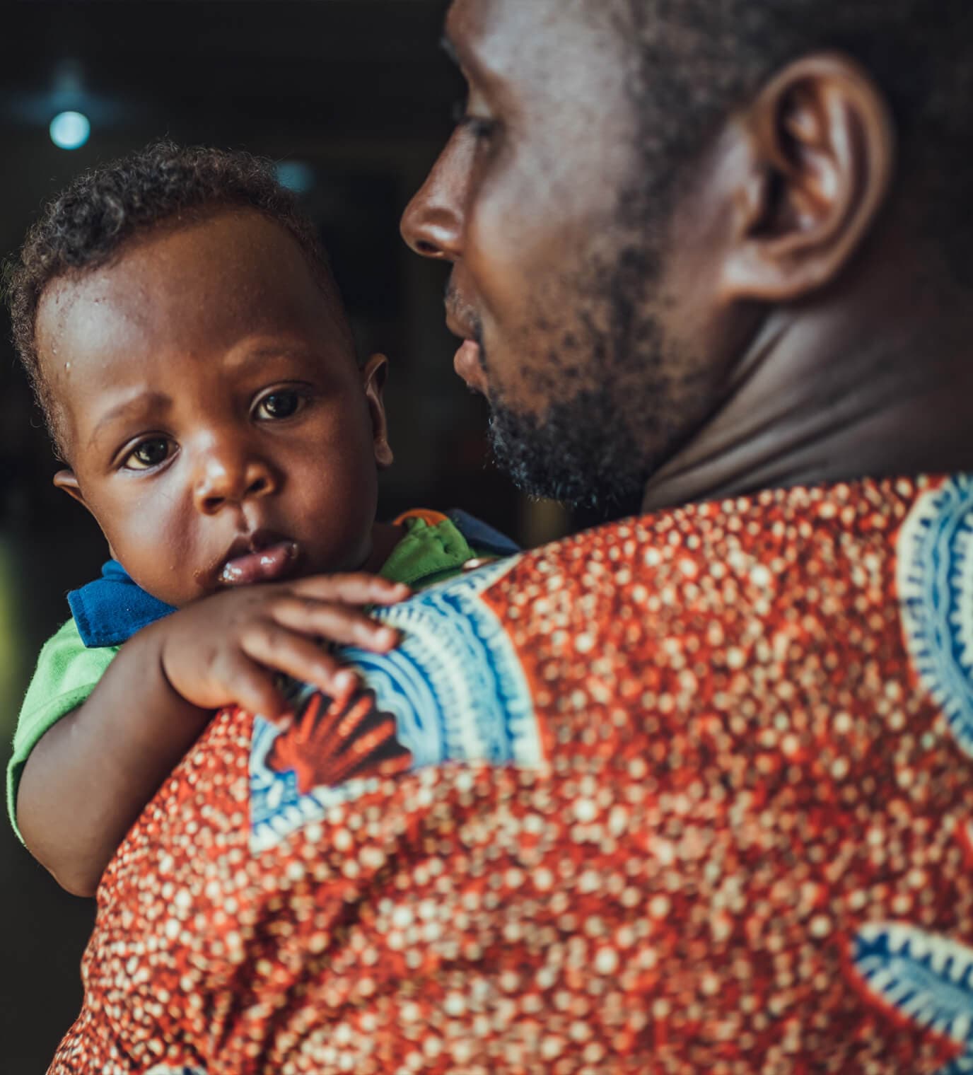 Person holding a baby close.