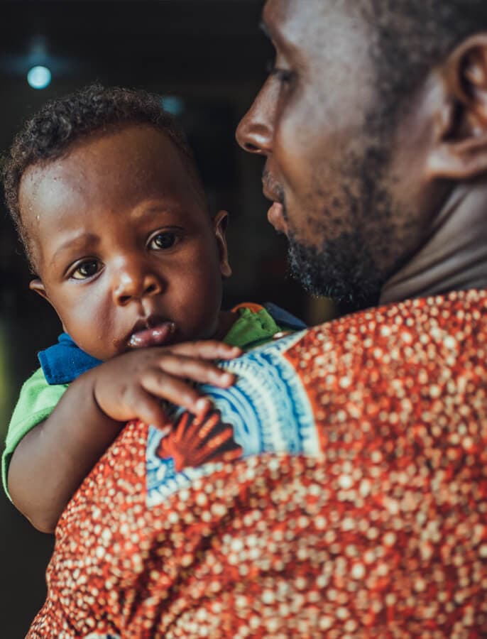Person holding a baby close.