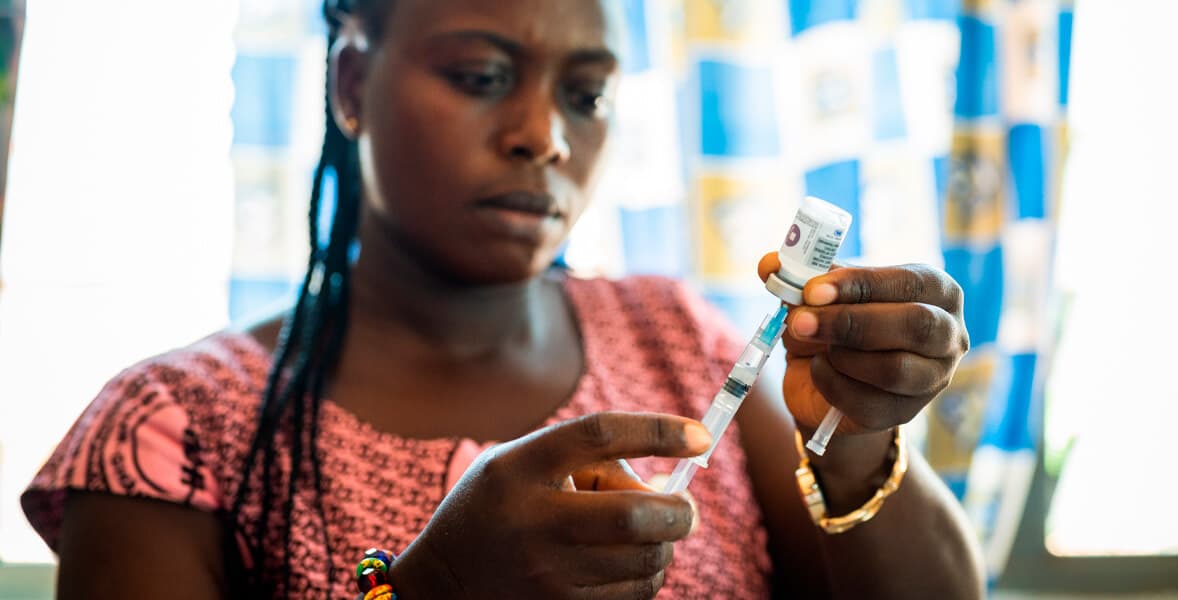 Healthcare worker preparing a vaccine syringe.