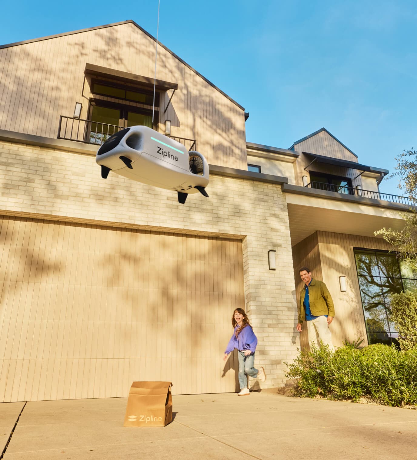 Zipline drone hovering above a delivered package outside a residential backyard.