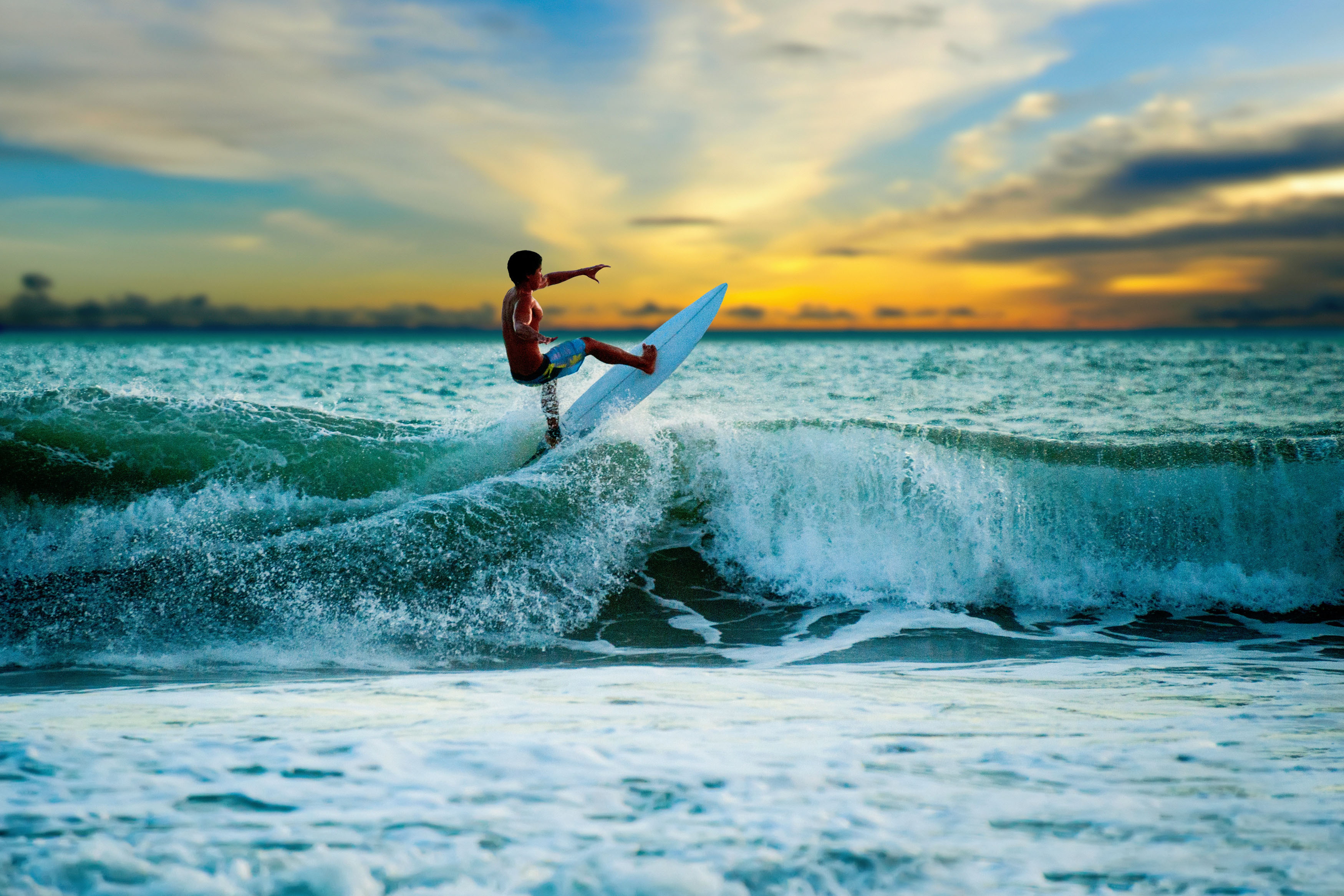 Athletic surfer with board on a wave in the ocean
